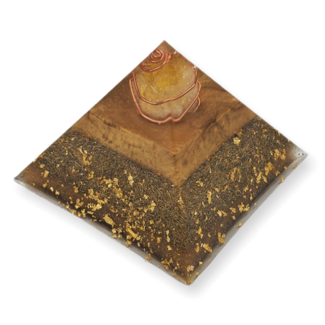 Pyramid-shaped orgonite with a stone on top on a white background