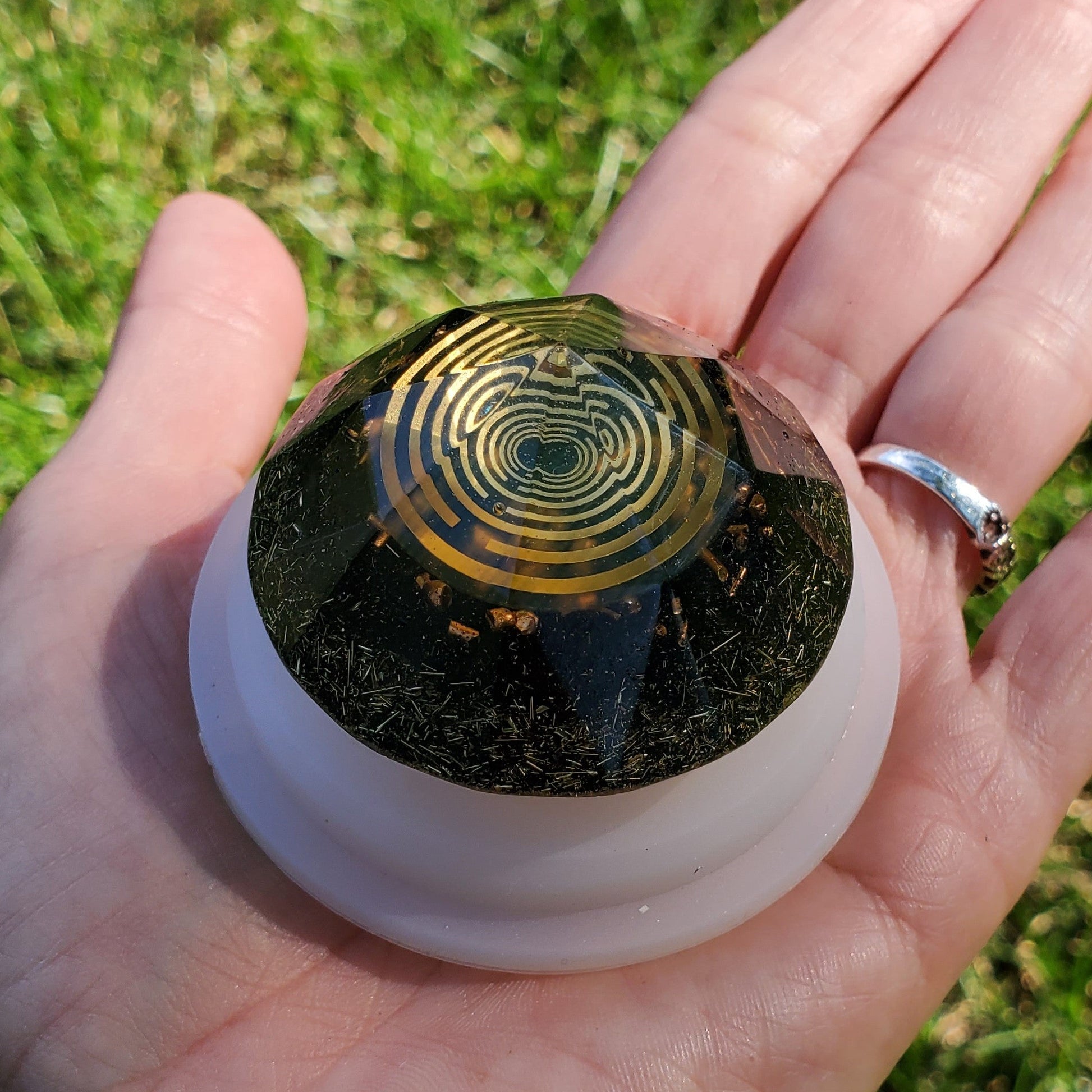 Hand holding an orgonite with a lachowski antena